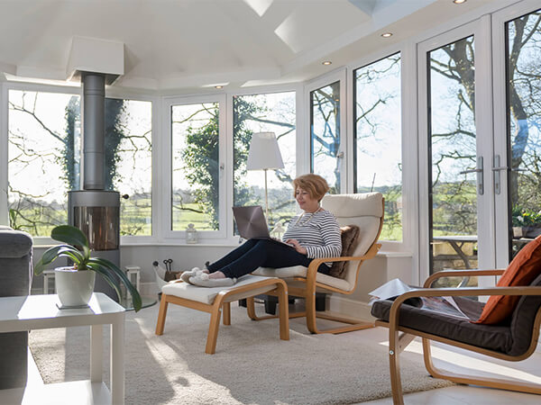 Lady working inside a solid roof conservatory